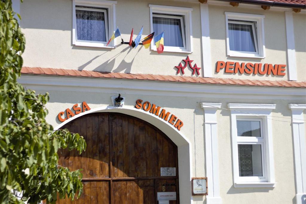 un edificio con una puerta de madera y un cartel en él en Casa Sommer, en Petreşti