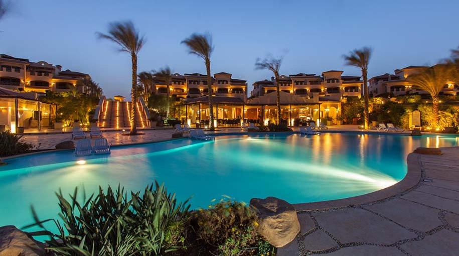 a large swimming pool at a resort at night at Relaxing chalet family only in Ain Sokhna
