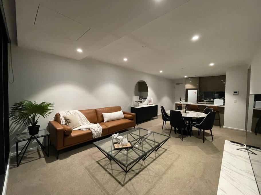 een woonkamer met een bank en een tafel bij Modern 3 Bedroom 2 Bathroom Apt Southbank in Melbourne
