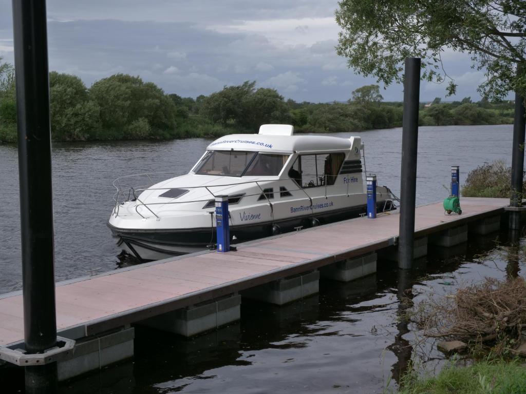 a boat is docked at a dock on the water at Vivienne in Ballymoney