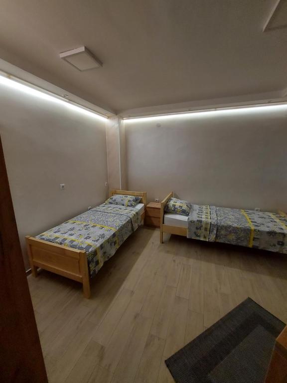 two beds in a room with lights on the wall at STIV Apartmani in Lukovo