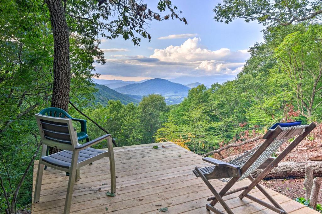 two chairs on a wooden deck with a view of mountains at Peaceful Spruce Pine Cabin on 8 Acres with 2 Decks! in Spruce Pine