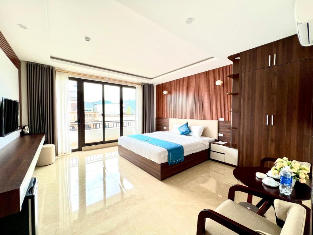 Khách sạn Ngọc Hà في لاو كاي: غرفة نوم مع سرير وغرفة معيشة مع طاولة