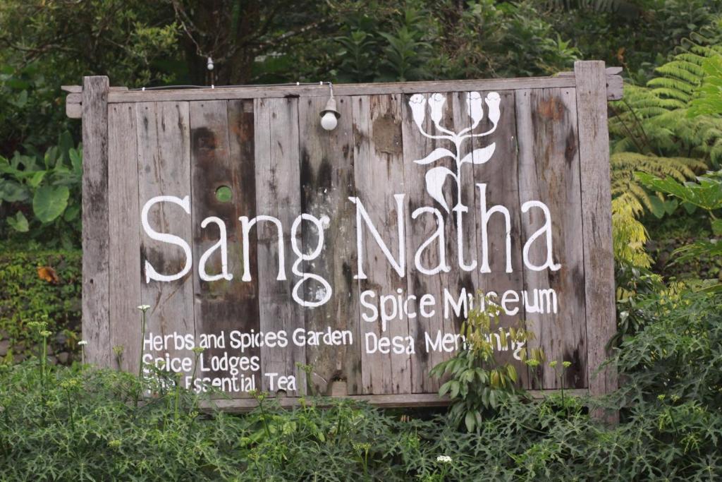een bord op een houten hek met een opschrift erop bij Sang Natha in Tjatur