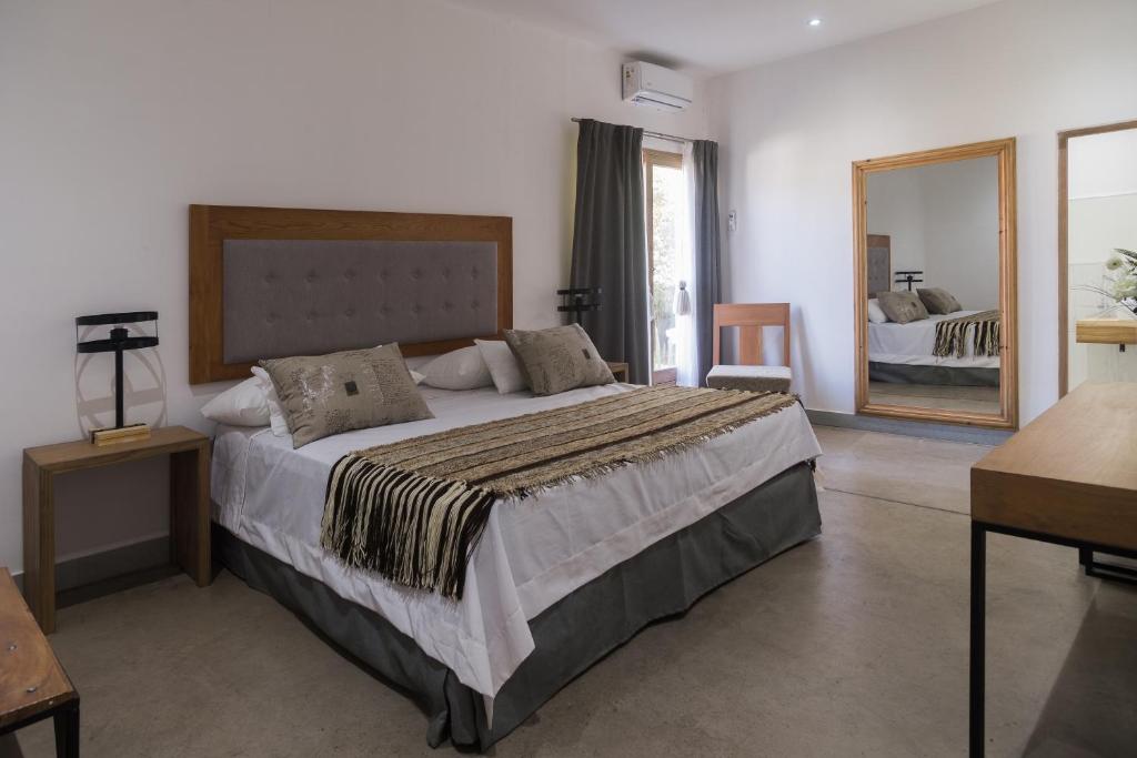 a bedroom with a large bed and a large mirror at Haus Apart Hotel in Salta