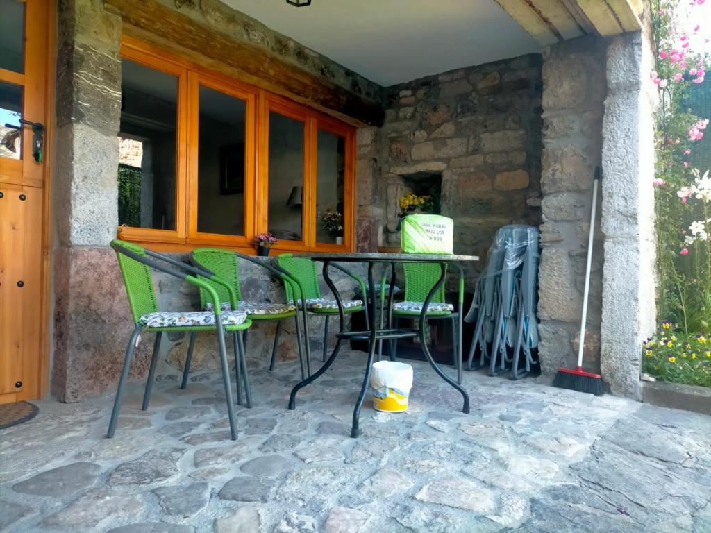 un patio con sillas y una mesa en un edificio de piedra en Bajo los nidos 2, en San Emiliano