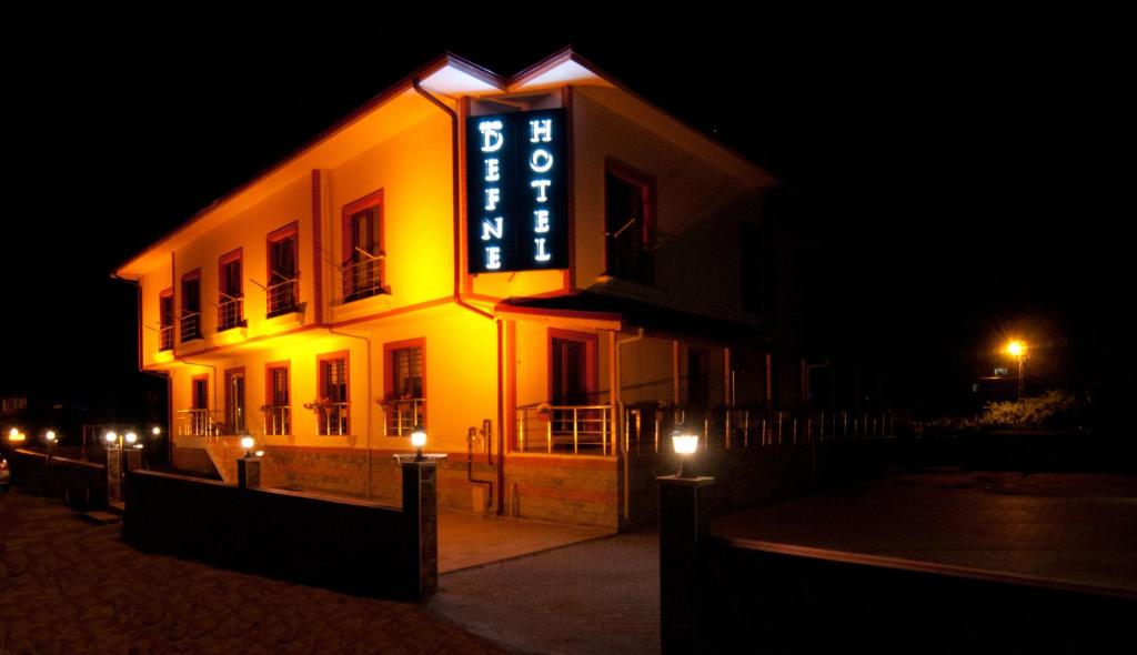 a building with a sign on the side of it at night at DEFNE OTEL in Şile