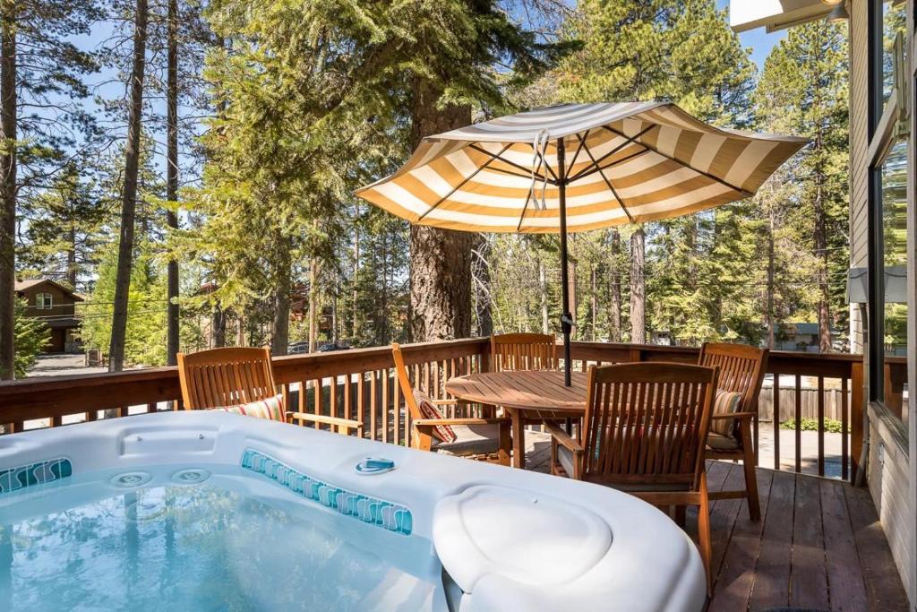 een hot tub op een terras met een tafel en een paraplu bij Sandy Shores Villa in Tahoe Vista