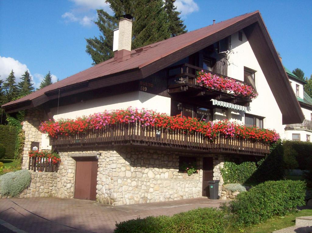un edificio con un balcón con flores. en Dueto, en Harrachov