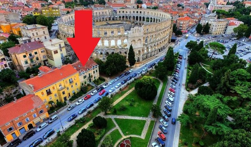 an aerial view of a city with a red arrow at Apartments Arena in Pula