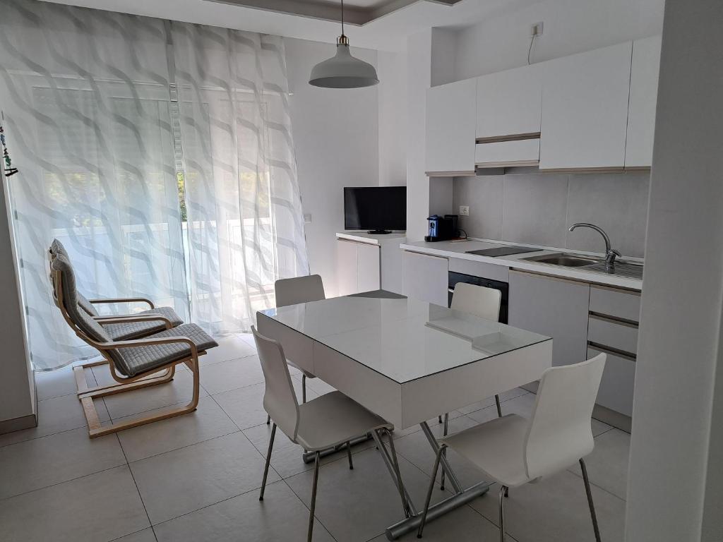 - une cuisine avec une table et des chaises blanches dans la chambre dans l'établissement Appartamento mare 49, à Vasto