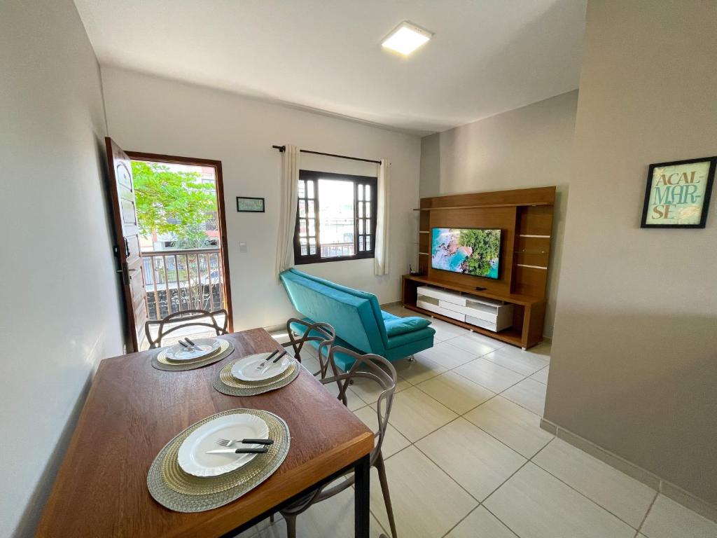 uma sala de estar com uma mesa de jantar e uma televisão em Apto Funcional próximo a Orla do Centro HS4 em Ubatuba