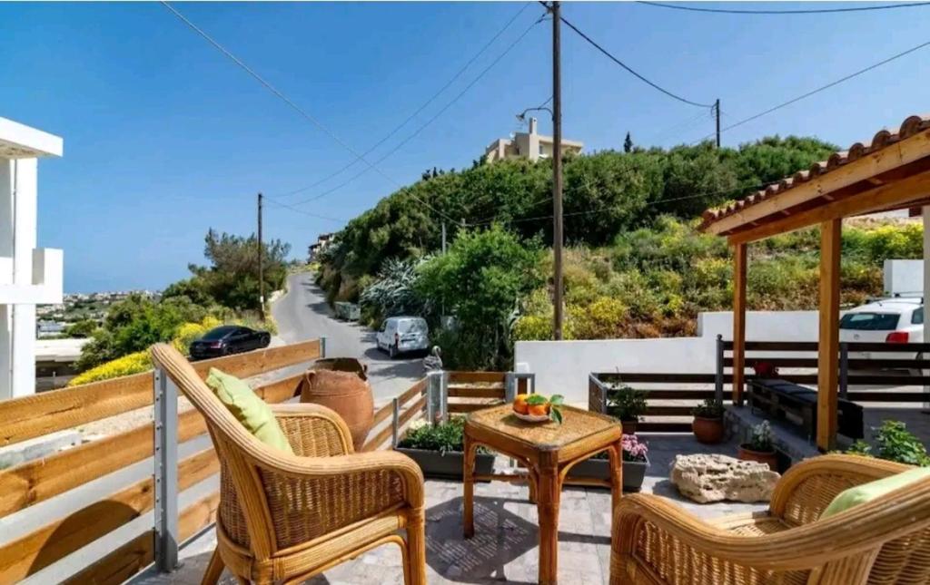 a patio with chairs and a table and a road at The Holiday House 3 in Heraklio