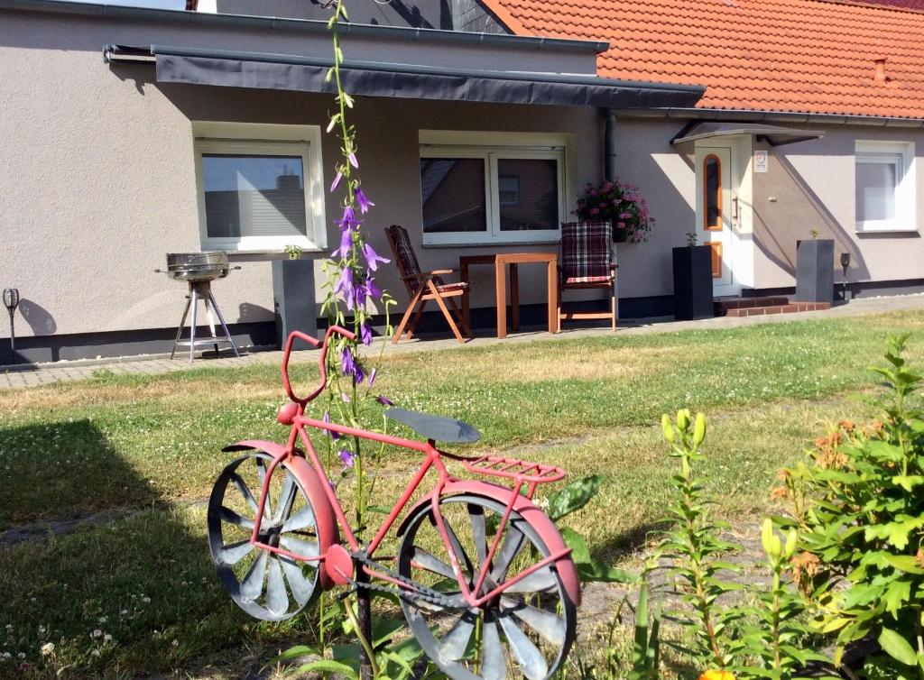 ein rosafarbenes Fahrrad, das im Hof eines Hauses geparkt ist in der Unterkunft Ferienappartement Paula im Lausitzer Seenland in Senftenberg