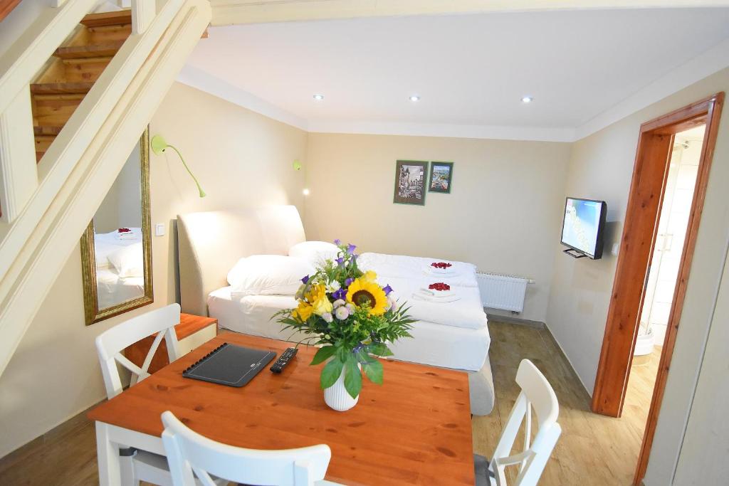 una habitación con una mesa con un ordenador portátil y flores en ella en Marcel Apartments Leipzig, en Leipzig