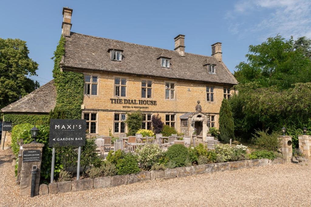 um grande edifício de tijolos com uma placa em frente em The Dial House em Bourton on the Water