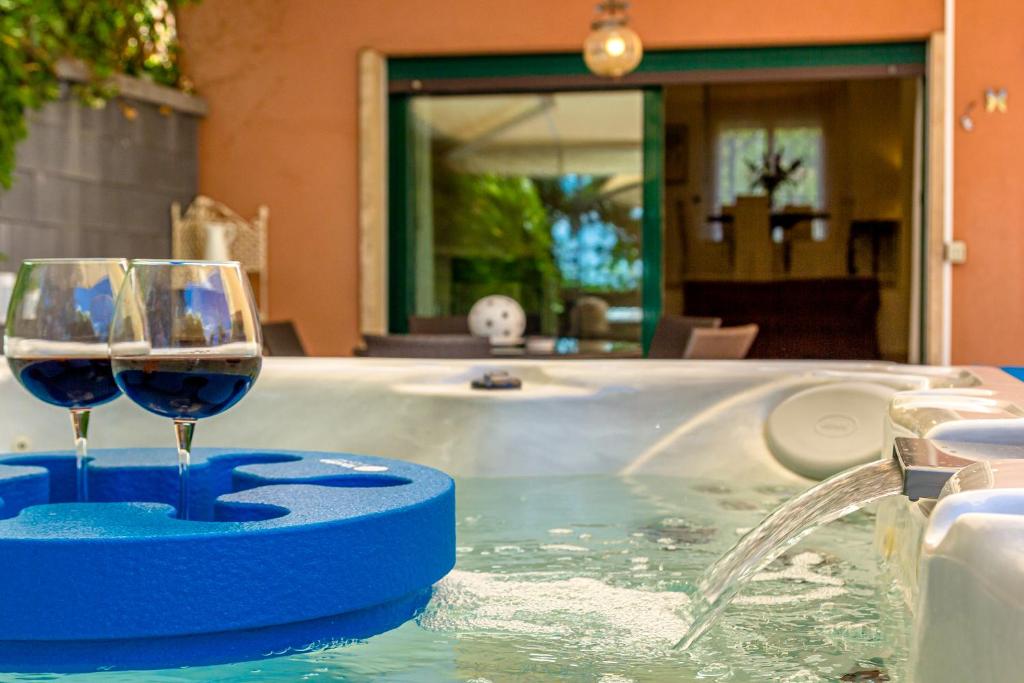 un bicchiere di vino seduto in una vasca idromassaggio di La Dimora Dei Ciclopi ad Aci Castello