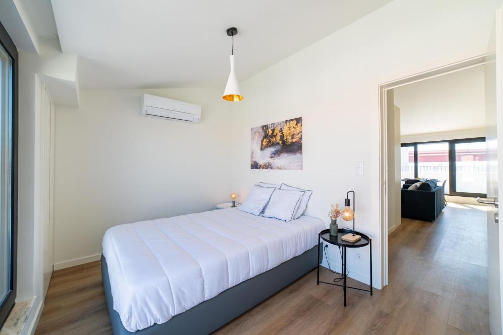 um quarto branco com uma grande cama branca num quarto em Lusíadas 53 5 D - Beautiful River View em Lisboa