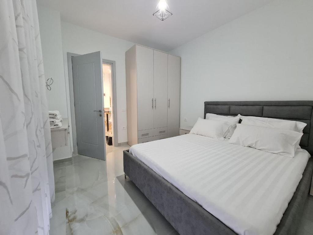 - une chambre blanche avec un grand lit et des draps blancs dans l'établissement Alvi apartment, à Golem