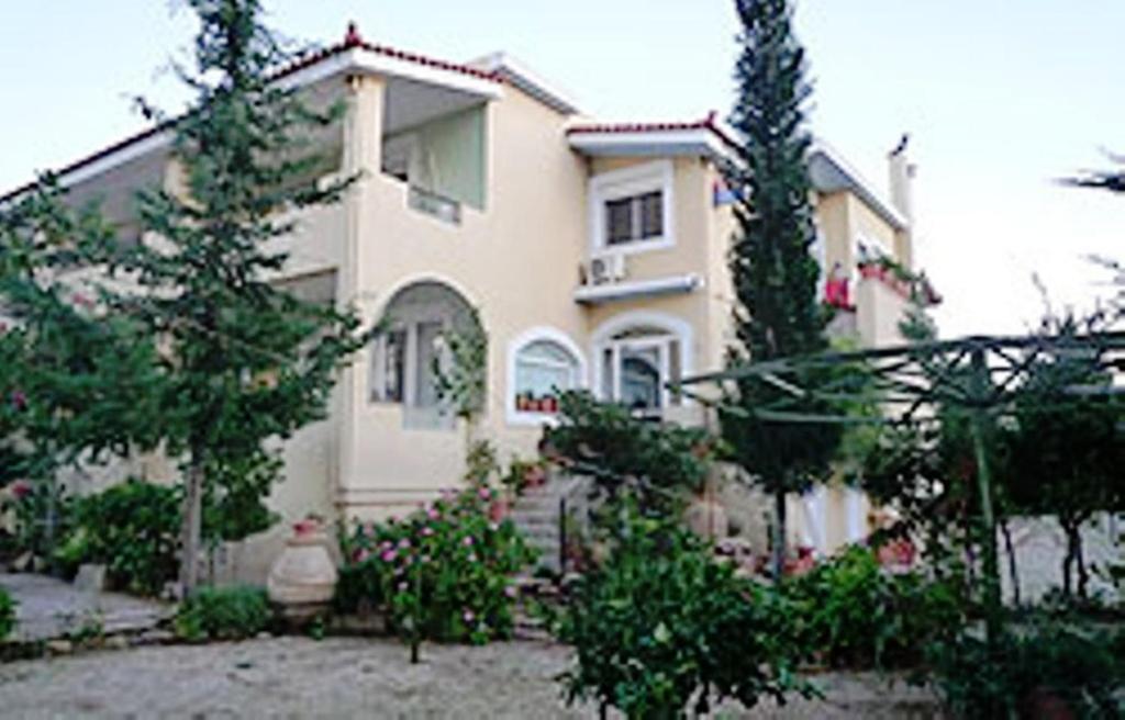 a large white house with trees in front of it at Kleidas Apartments in Thymianá
