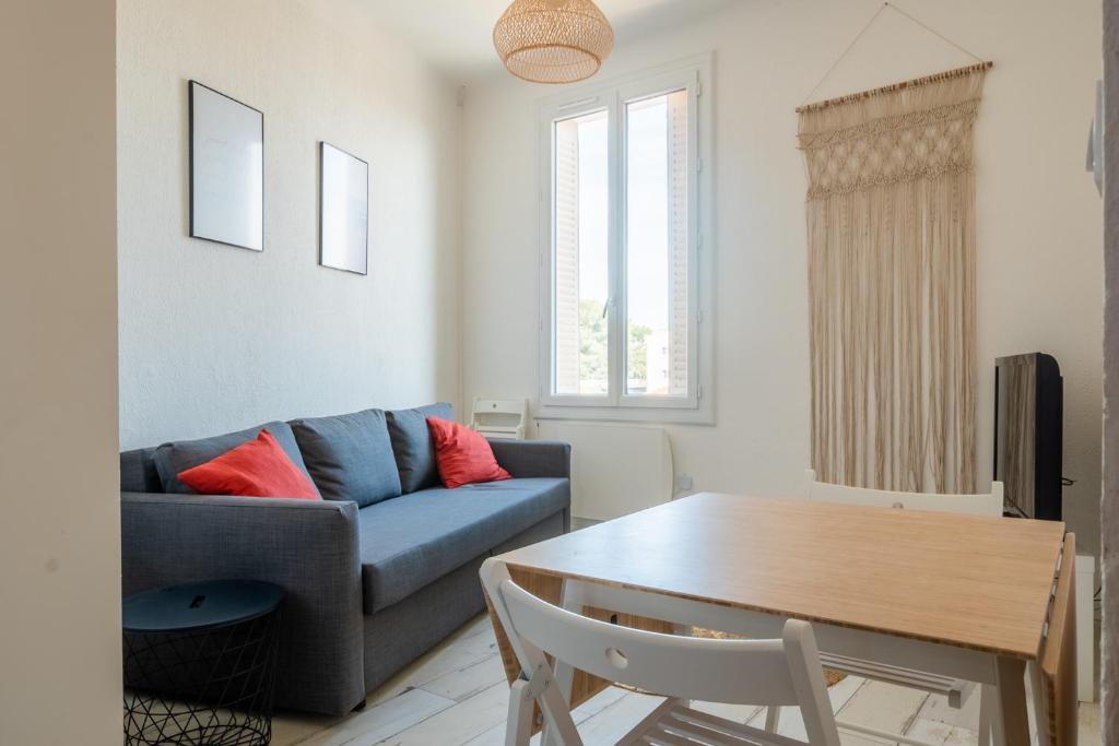 een woonkamer met een blauwe bank en een tafel bij Duplex, vue mer, proche du centre ville, 4P in Toulon