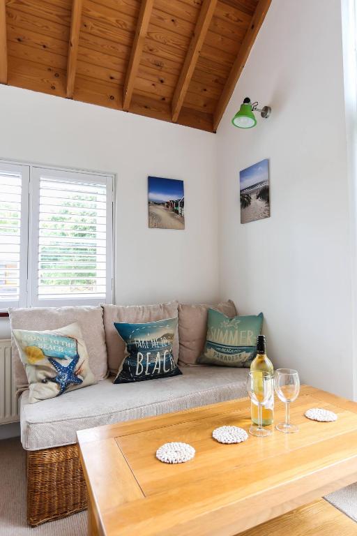 a living room with a couch and a table at Linden House in West Wittering