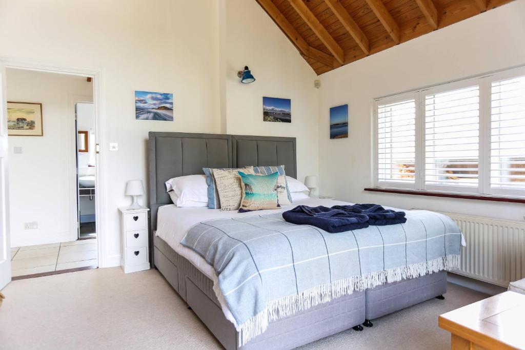 a bedroom with a large bed and a window at Linden House in West Wittering