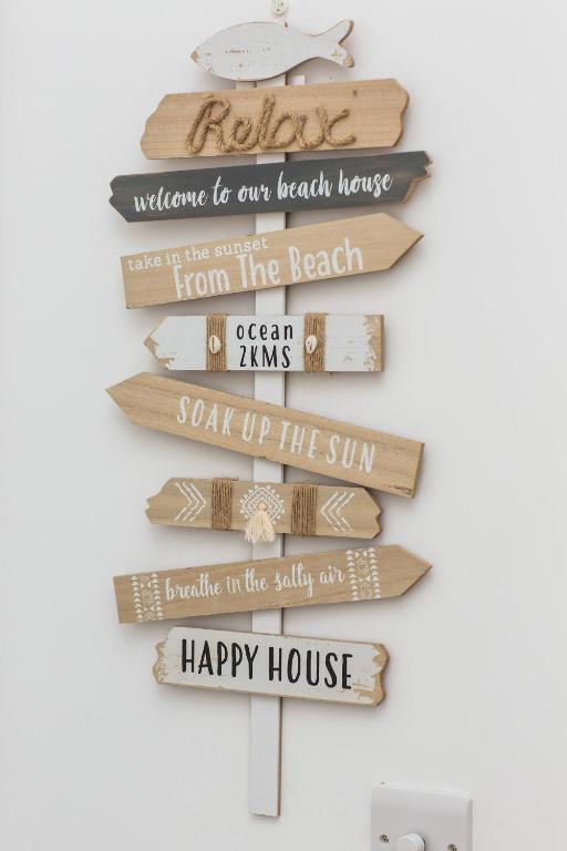 a sign for our beach house happy house at Linden House in West Wittering