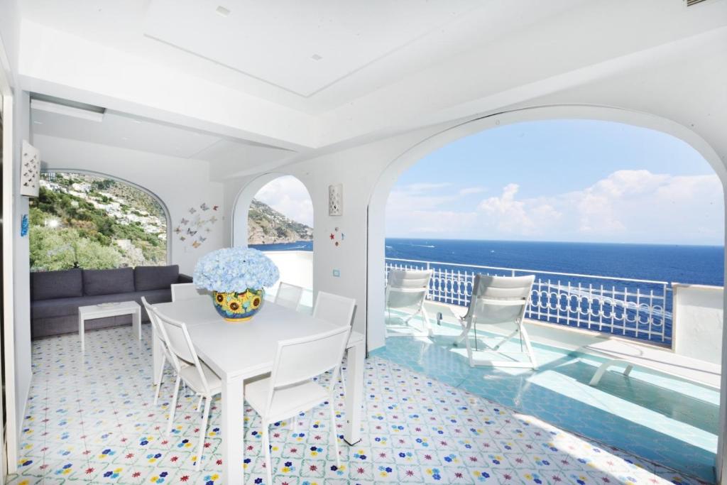 une salle à manger blanche avec vue sur l'océan dans l'établissement Villa sul mare - Praiano (Amalfi Coast), à Praiano