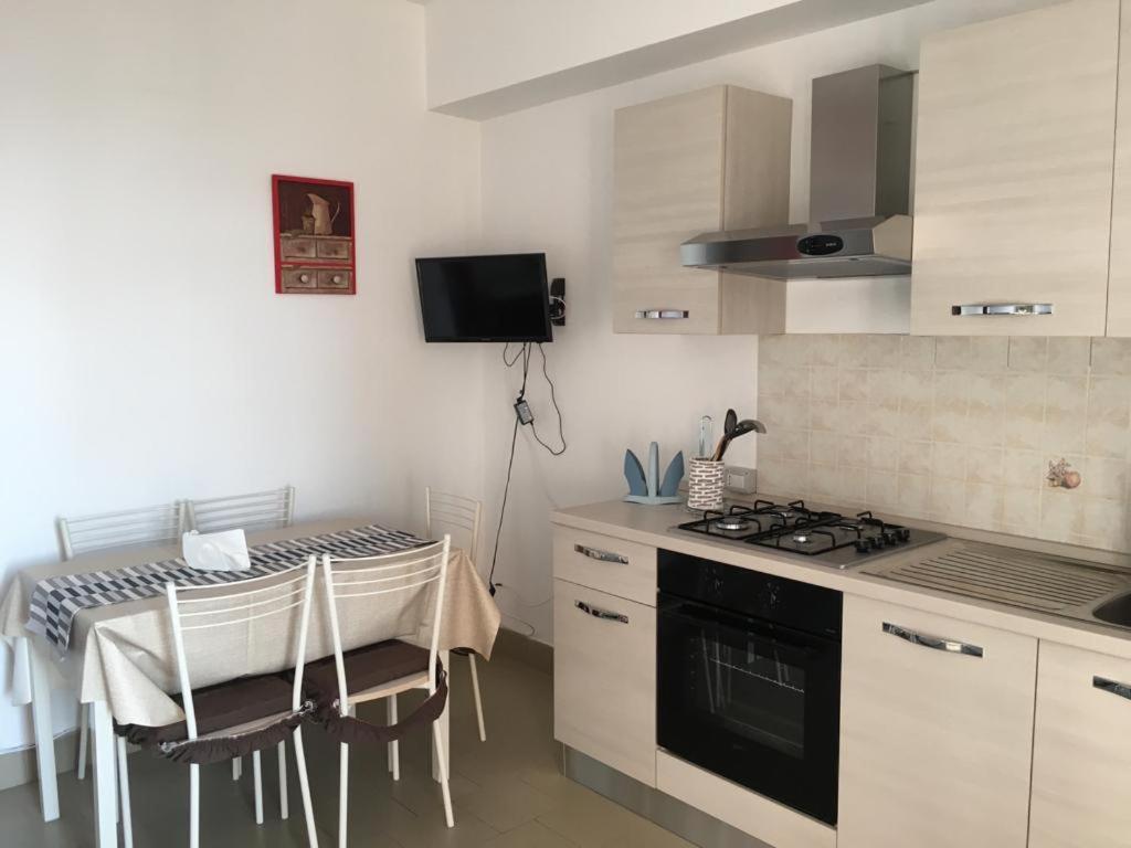 uma cozinha com uma mesa e um fogão forno superior em Frank Sinatra - Appartamento vicino Taormina em SantʼAlessio Siculo