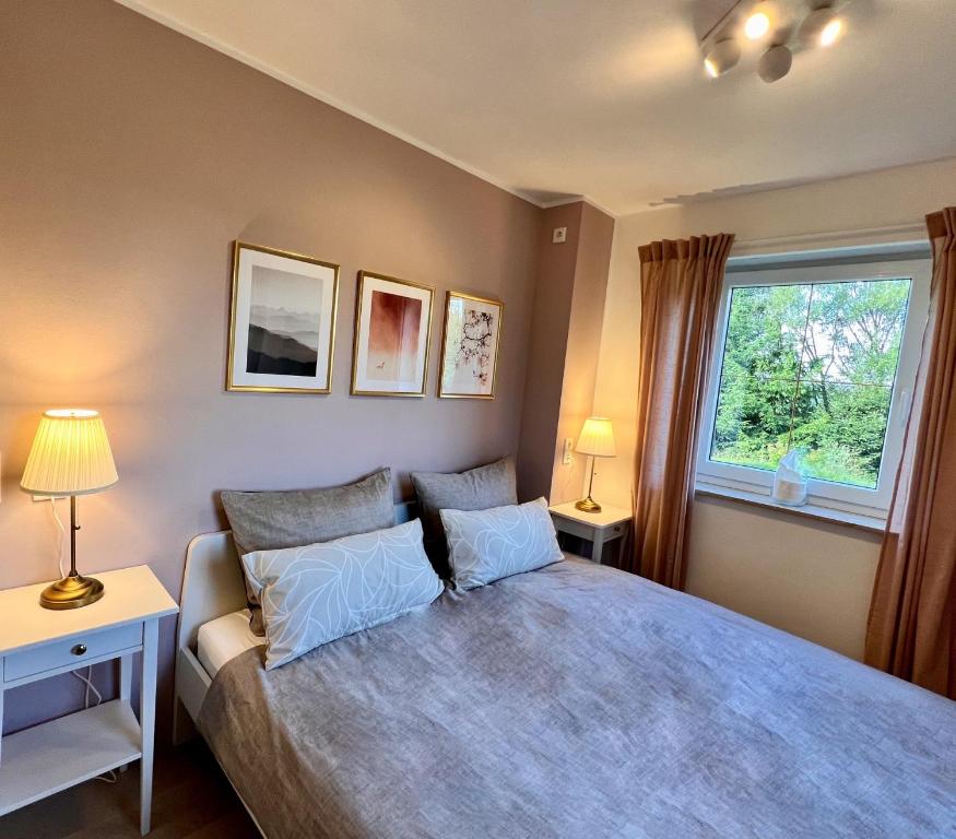 um quarto com uma cama com 2 candeeiros e uma janela em Luxus Ferienhaus Erzgebirge in Alleinlage em Kurort Altenberg