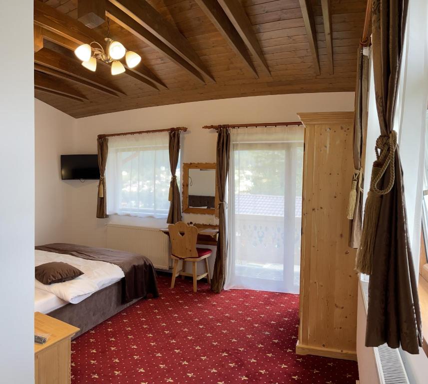 - une chambre avec un lit et un bureau dans l'établissement Casa Belcin Spa&Retreat, à Buşteni