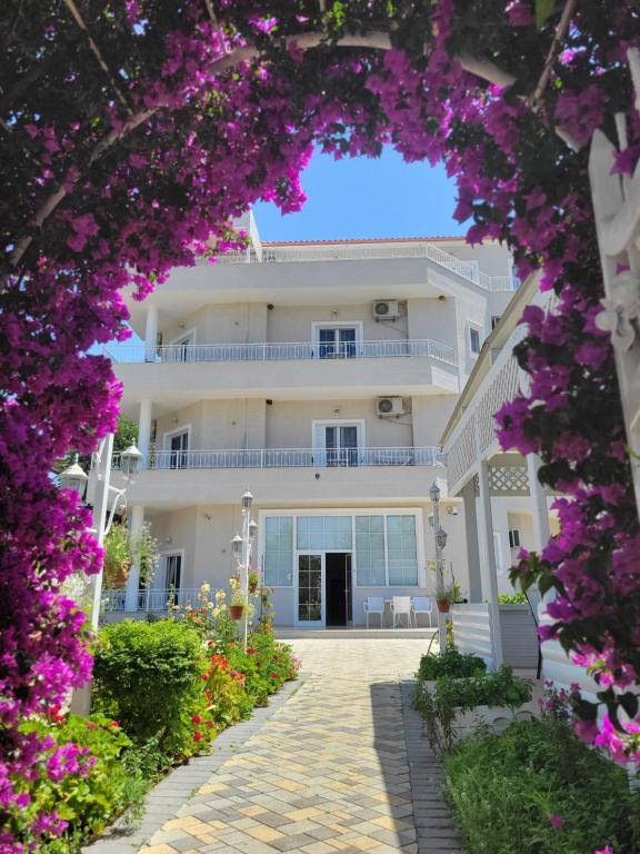 - une vue sur un bâtiment orné de fleurs violettes dans l'établissement Villa August Ksamil, à Ksamil