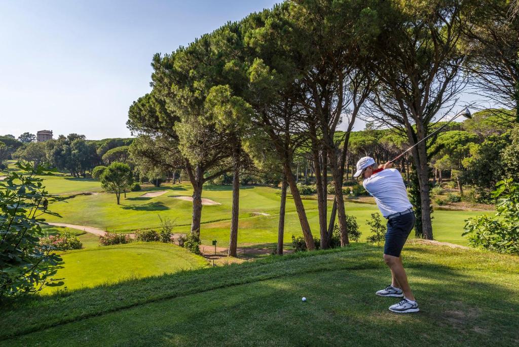 a man swinging a golf club on a golf course at Golf Hôtel de Valescure &amp; Spa NUXE in Saint-Raphaël