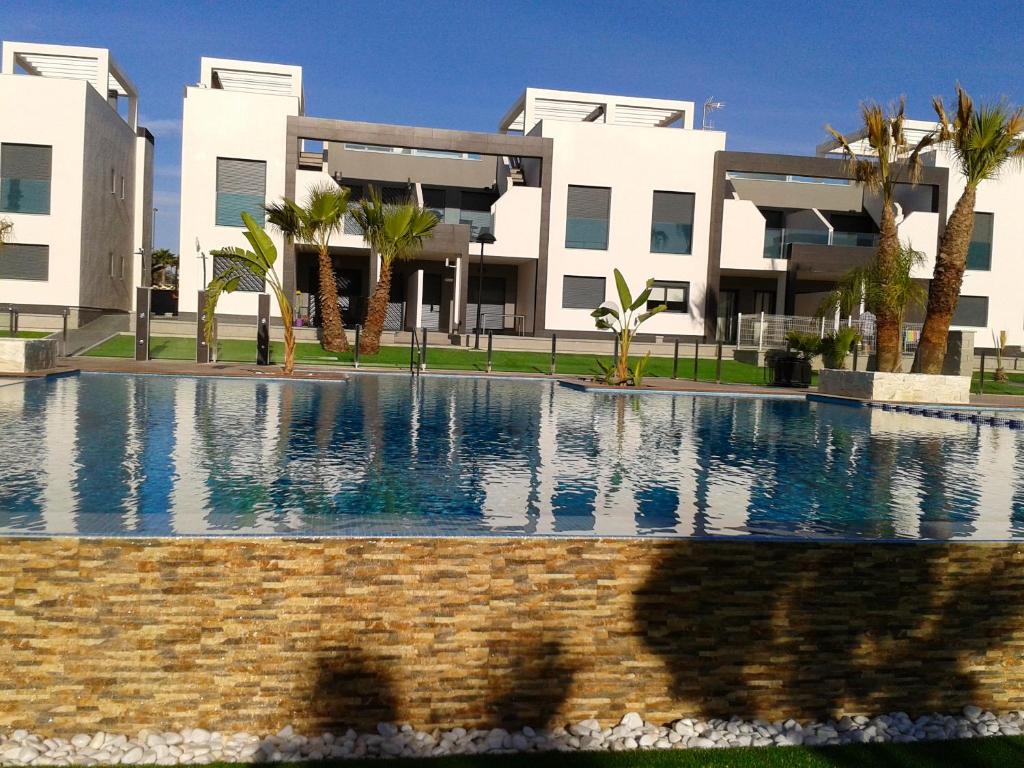 einem großen Pool vor einem Gebäude in der Unterkunft 2 bedrooms appartement with shared pool furnished terrace and wifi at Orihuela 1 km away from the beach in Playa Flamenca