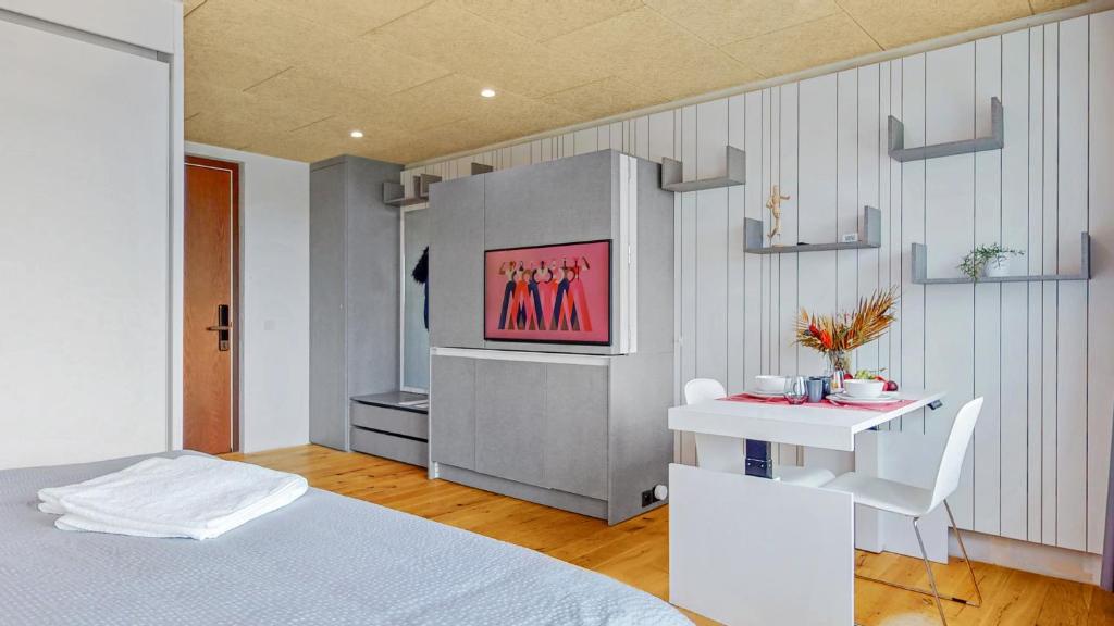 ein Schlafzimmer mit einem Bett und einem TV an der Wand in der Unterkunft Evi's Home Hotel & Apartments in Bern