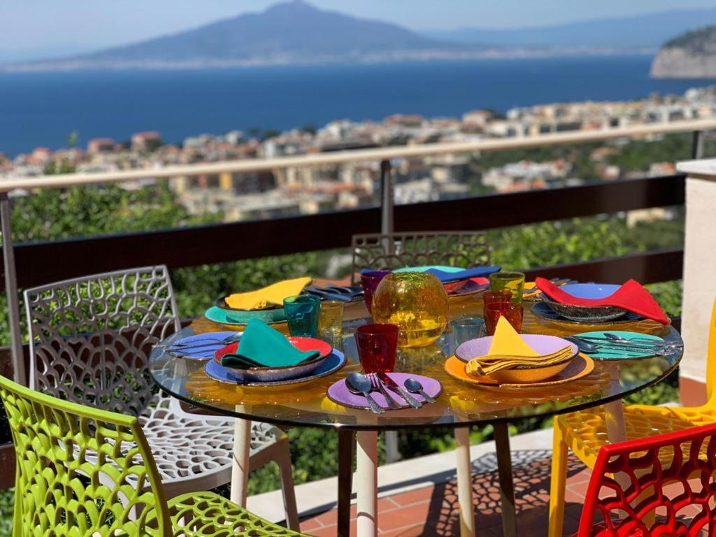 une table avec des assiettes de nourriture sur un balcon dans l'établissement CASA ACAMPORA, à Sorrente