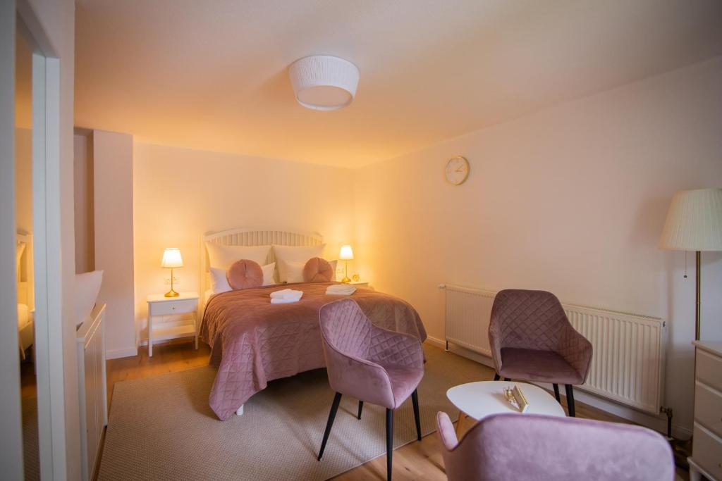 1 dormitorio con 1 cama con 2 sillas y 1 mesa en ApartOne Land-Hotel en Sebnitz