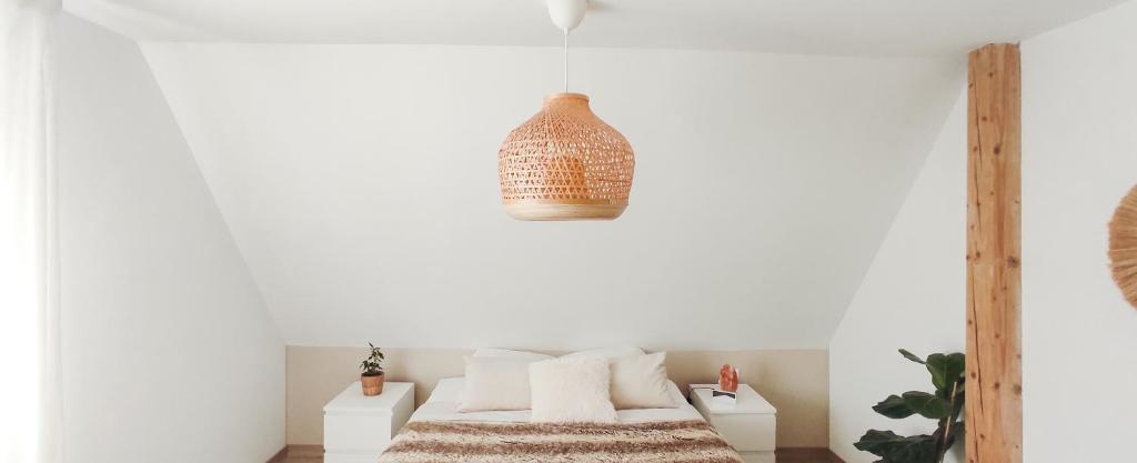una camera da letto con pareti bianche e un letto con cuscini bianchi di Cocoon Bed and Breakfast a Fegersheim