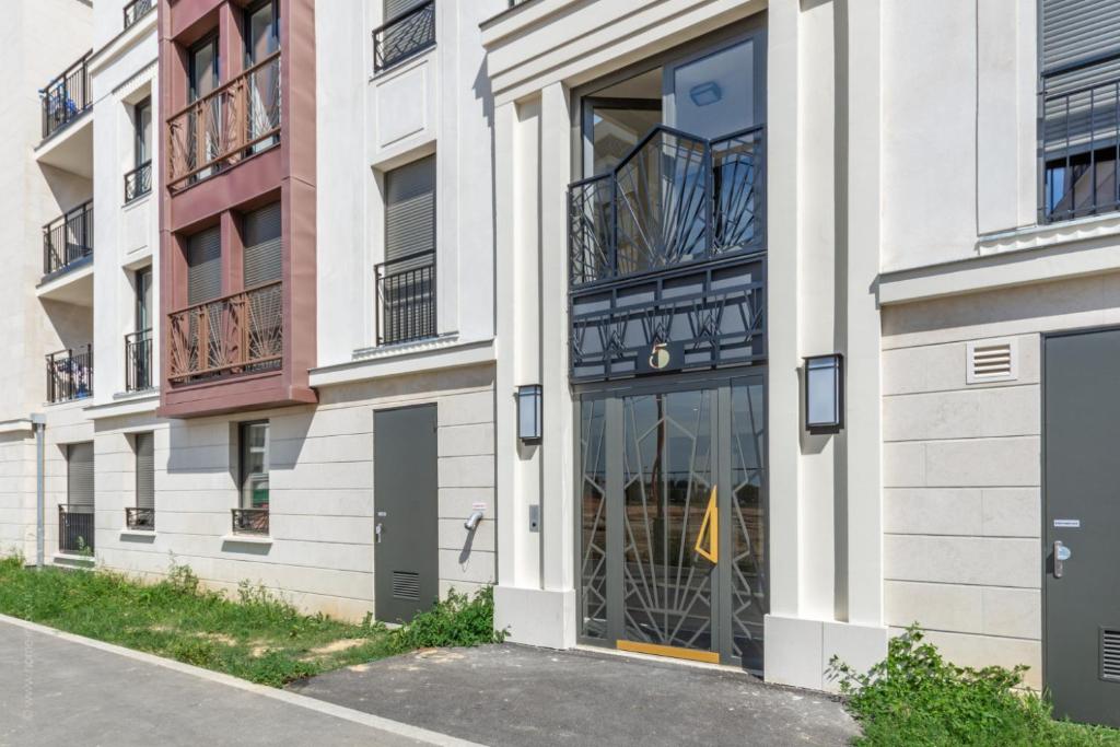 an apartment building with glass doors and balconies at La Bella Vita By Plaza in Chessy