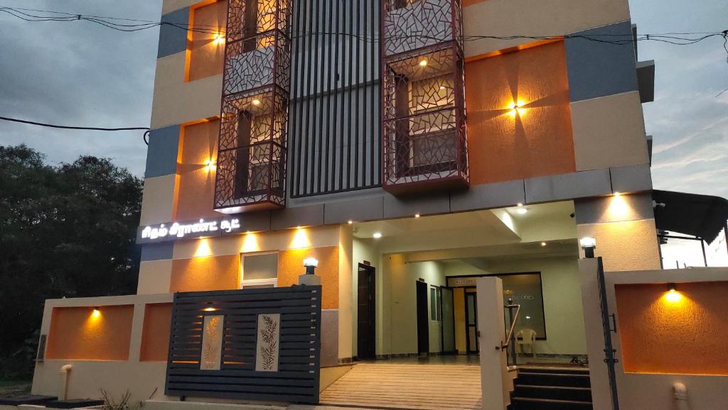 um edifício com luzes na frente em Hotel Rhythm Grand Suite em Tiruchchirappalli