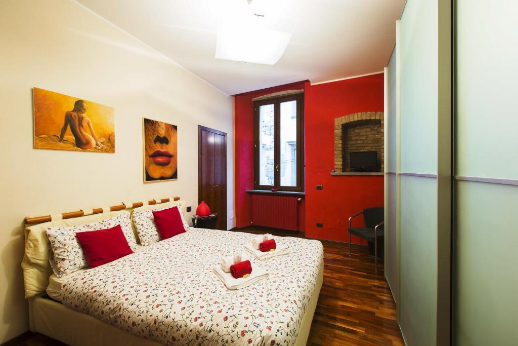 a bedroom with a bed with red walls at La Rosa Scarlatta in Bergamo