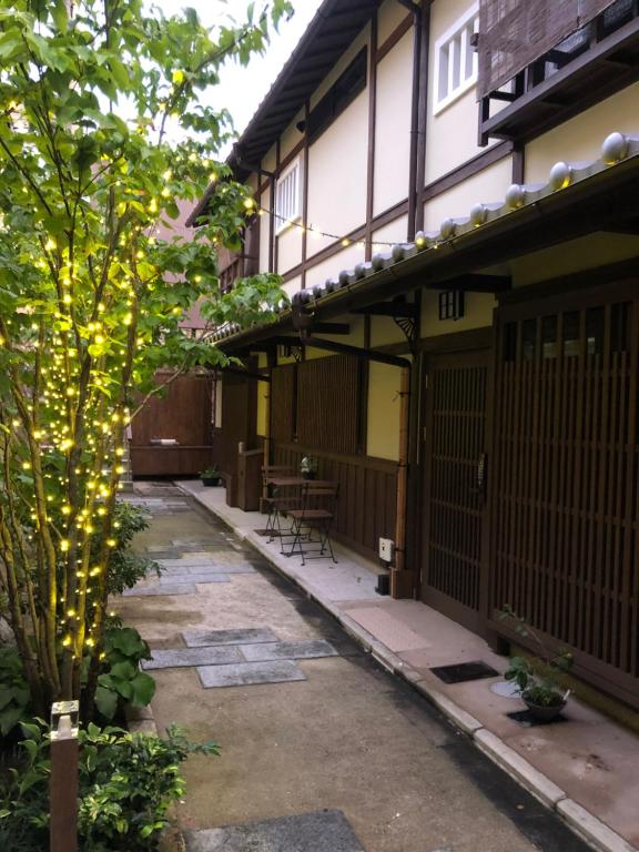 une cour avec un arbre et des lumières dans l'établissement Imakumano Terrace - Dohachi An 道八庵, à Kyoto