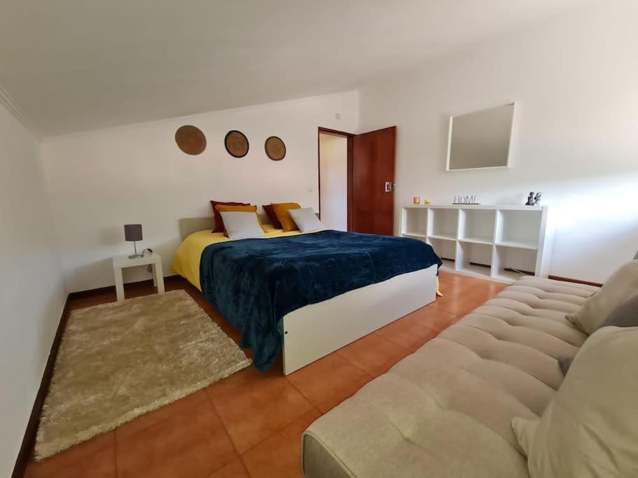 a bedroom with a bed and a couch at Alojamento 3 vistas in Sintra