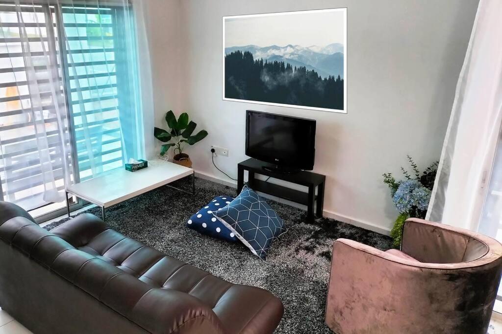 ein Wohnzimmer mit einem Sofa und einem TV in der Unterkunft IRIS 55 Corner Lot House Spacious Outdoor With Wi-Fi in Johor Bahru