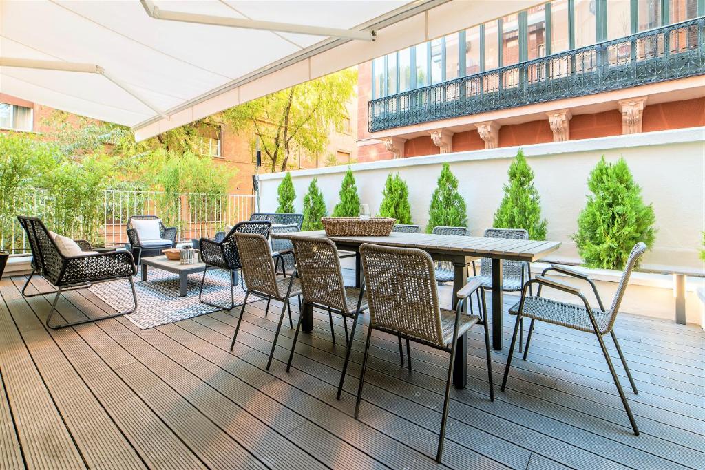 a patio with a table and chairs on a deck at Espectacular piso de lujo 360 m2 en Madrid, excelente ubicación, muy cerca del Palacio Real in Madrid