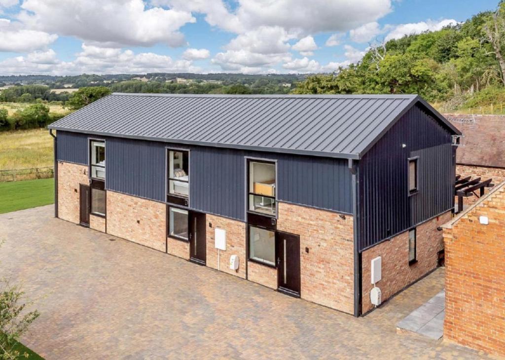 an image of a house with a black roof at Fawn Cottage disabled adapted 3 bed cottage in Coughton