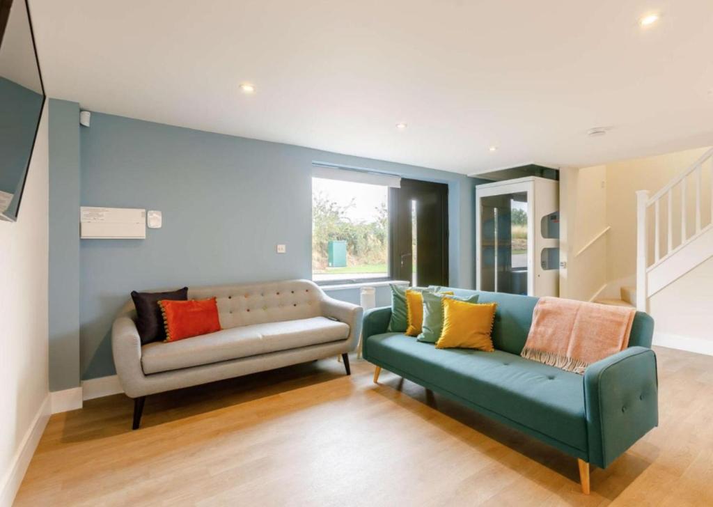 ein Wohnzimmer mit einer Couch und einem Sessel in der Unterkunft Fully Accessible-Disabled Adapted-Hot Tub-Pets in Coughton