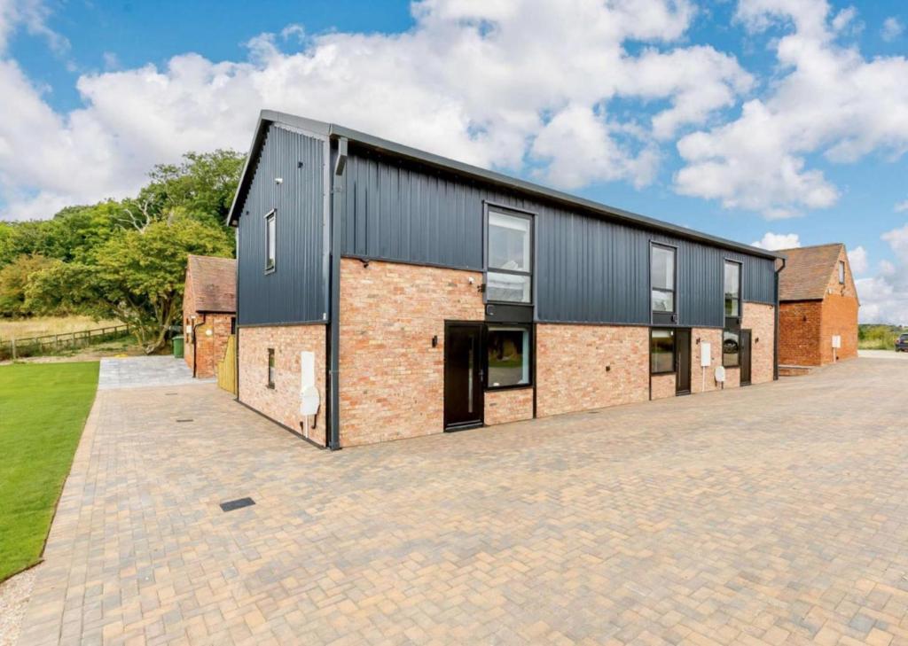 an external view of a house with a brick driveway at Buck Cottage disabled adapted 3 bed cottage in Alcester