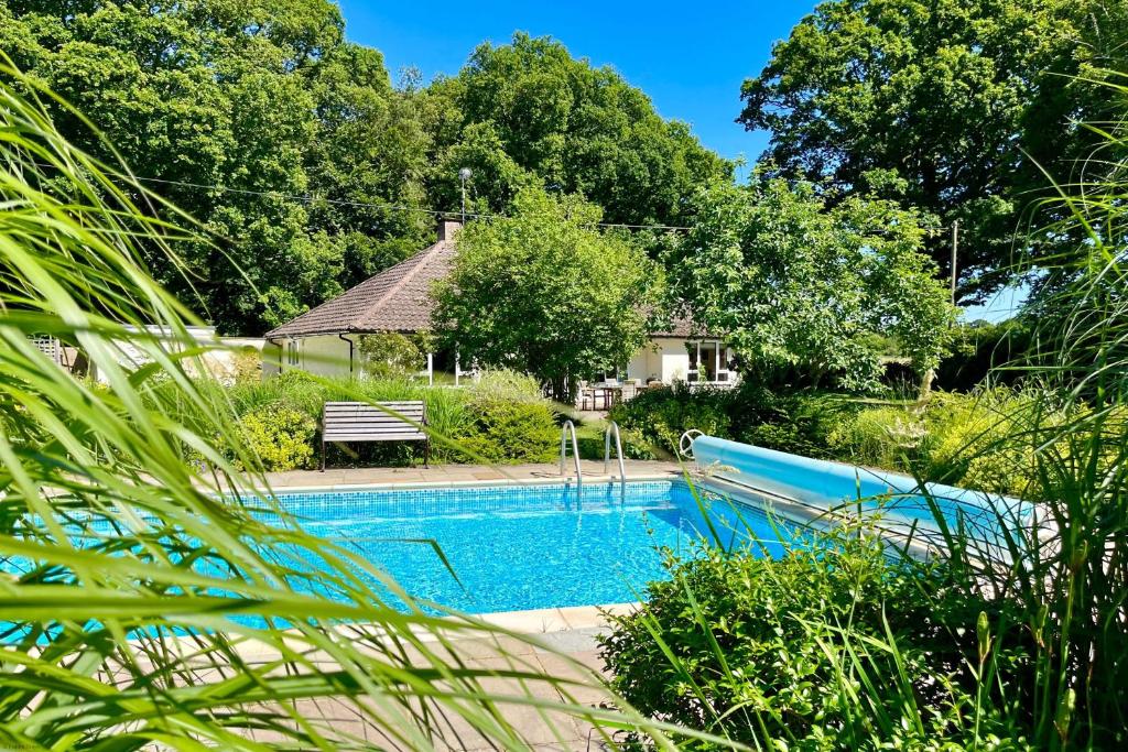 a swimming pool in front of a house at Bell Meadow in Coldwaltham